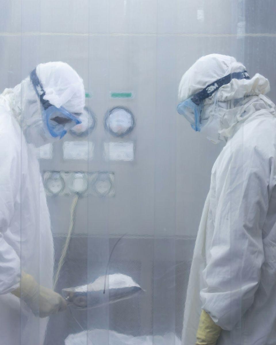 Techniciens en combinaison de décontamination